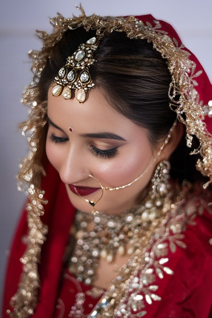 gallery-1 A beautiful bride adorned in Indian wedding attire with intricate jewelry.